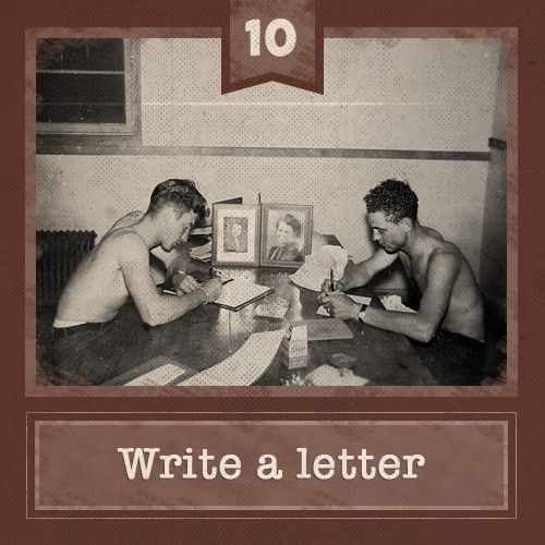 Vintage men sitting at table shirtless writing letters. 