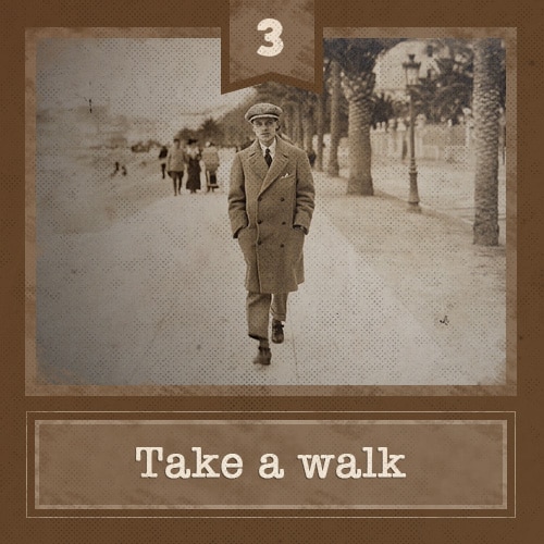 Man walking on path wearing a long coat.