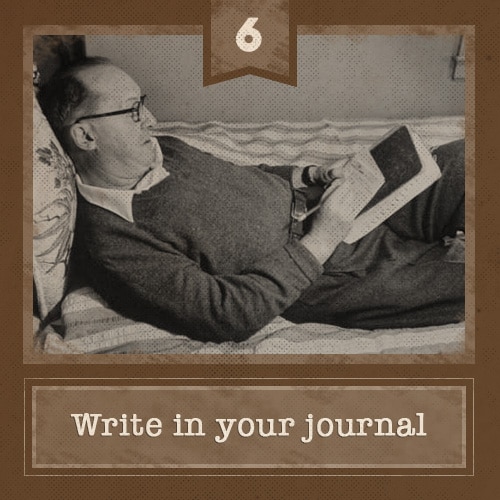 Man lying in bed writing in journal. 