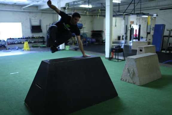 Man jumping over concrete barrier.