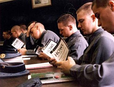 A group of men engrossed in reading poems at a table.