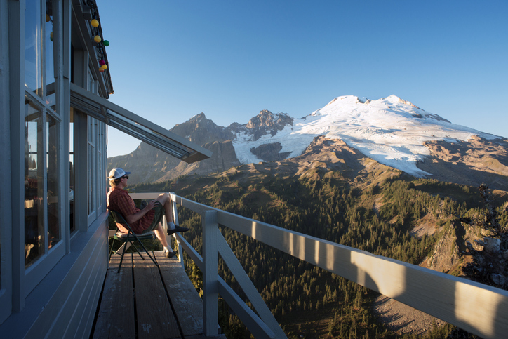 A person sitting on a wooden deck, off the grid.