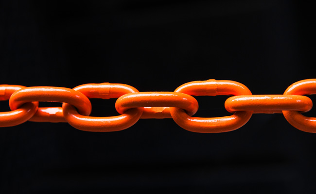 An orange chain on a black background represents the process of breaking habits.