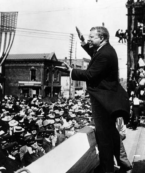 A man in a suit giving a speech to a crowd, making history.