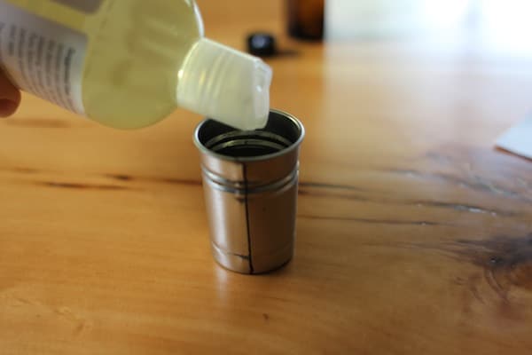 Beard oil pouring into measuring glass. 