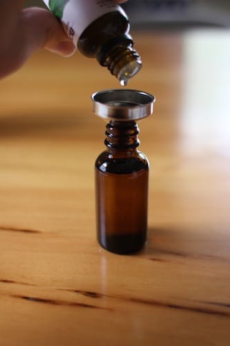 Beard oil pouring into small bottle. 