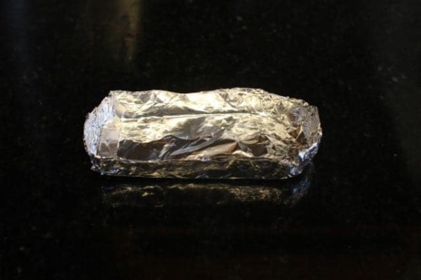 Aluminum foil container for smoke bomb on a black marble.