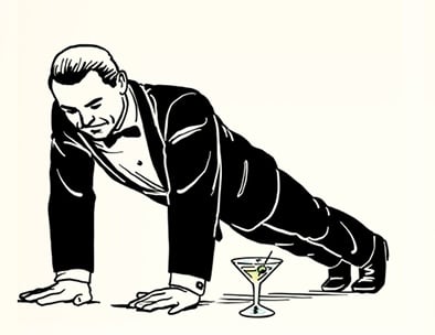 A man in a tuxedo performs a James Bond workout, executing a push-up over a martini glass on the floor.