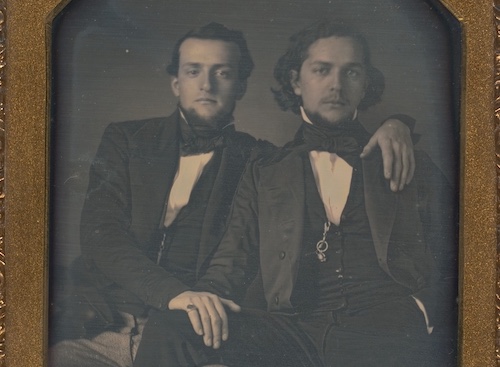 Two men in tuxedos posing for a photo at Sunday Firesides.