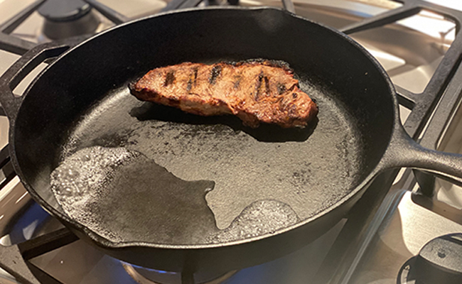 The best way to reheat steak is by using a frying pan on a stove.