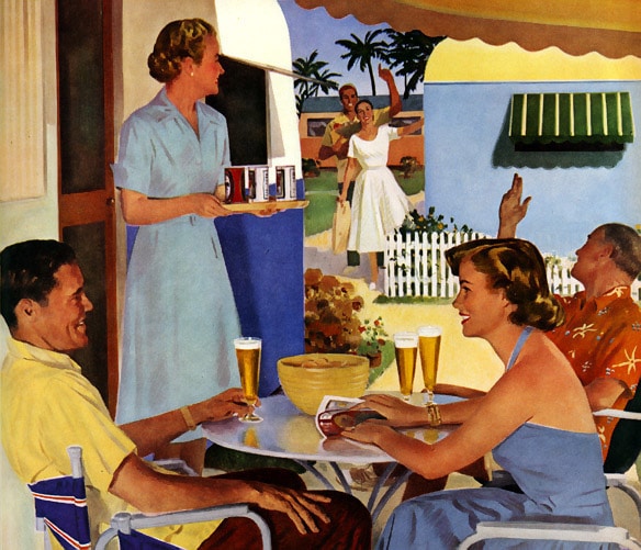 A group of people sitting at a table enjoying beer during summertime.