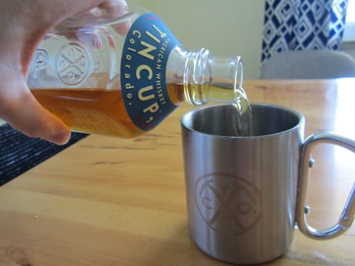 A man pouring whiskey into cup. 