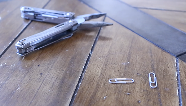 Pair of pliers and metal clips displayed.